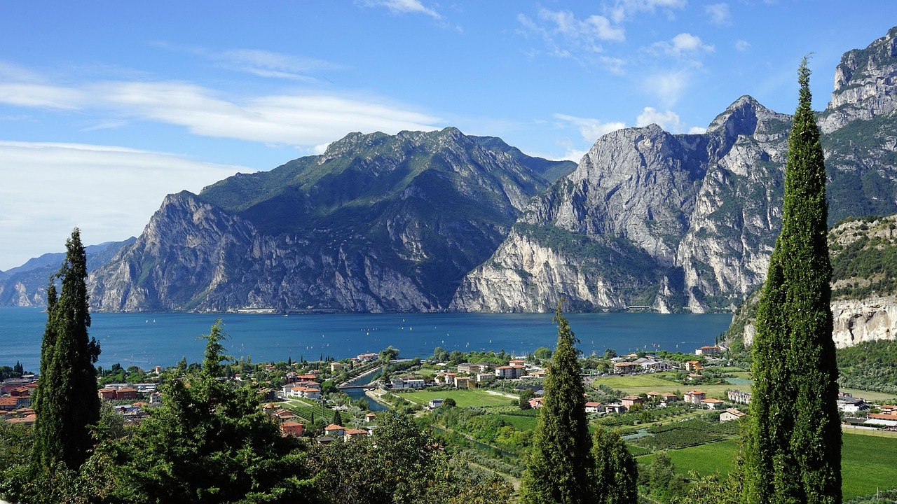 Panorama mozzafiato del Lago di Garda con acque azzurre e colline verdi sullo sfondo.