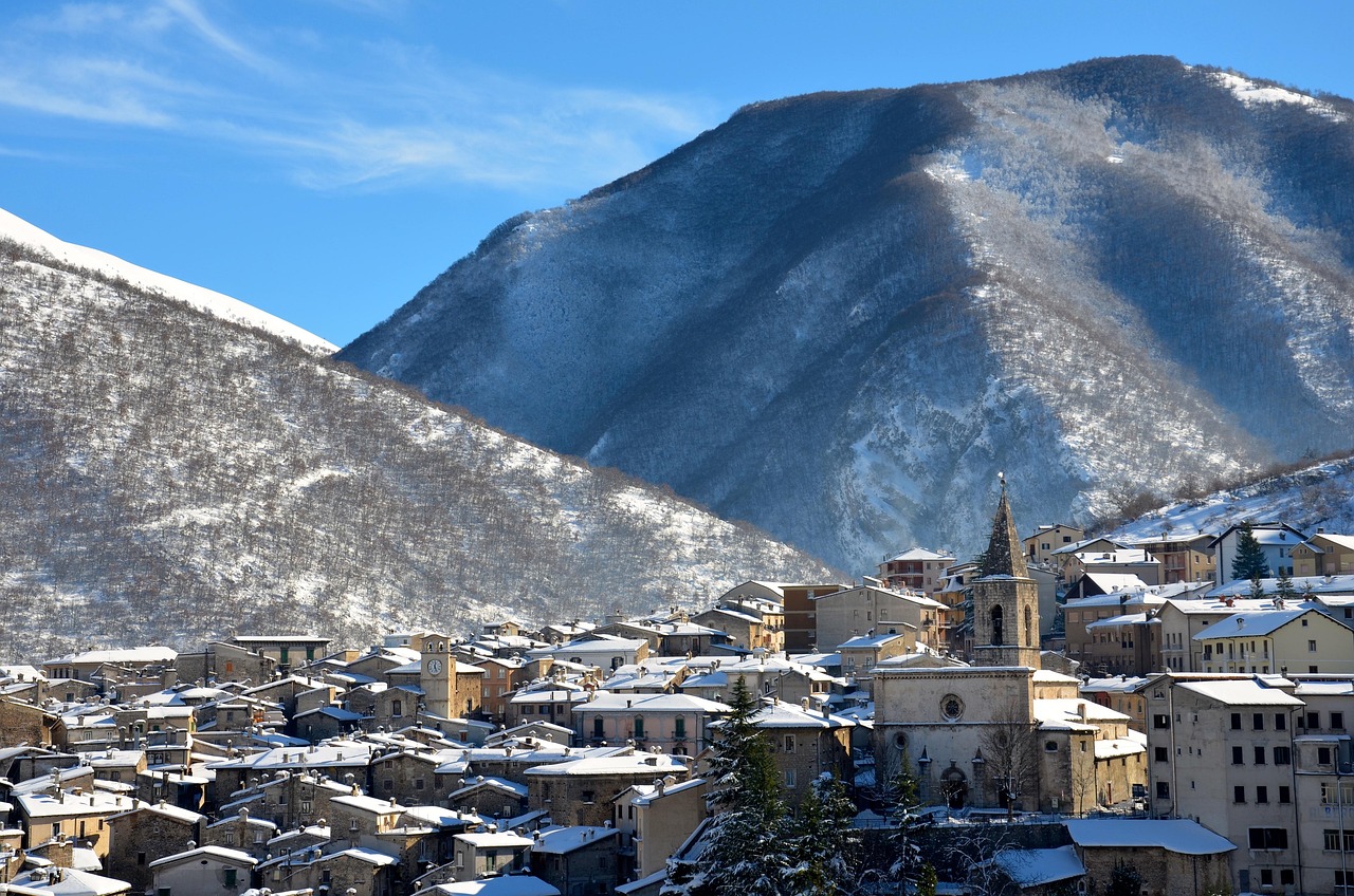 Panorama di un pittoresco borgo di montagna vicino a Brescia, circondato da verdi valli e cime alpine.