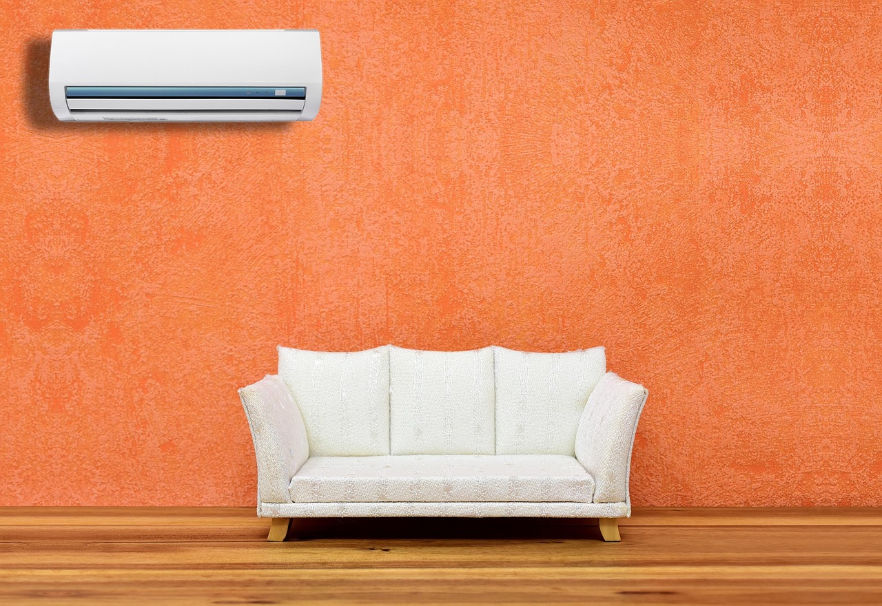 Climatizzatore inverter in funzione con grafico delle bollette in aumento sullo sfondo.