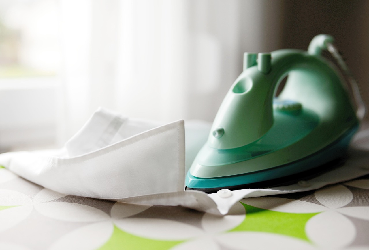 Colletto di camicia macchiato di giallo, con prodotti per la pulizia in evidenza.