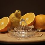 Estrattore di succo moderno su un tavolo con frutta fresca e verdura circostante, pronto all'uso.