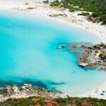 Spiaggia della Sardegna, vista panoramica, accessibile solo a piedi, con acque cristalline e sabbia bianca.