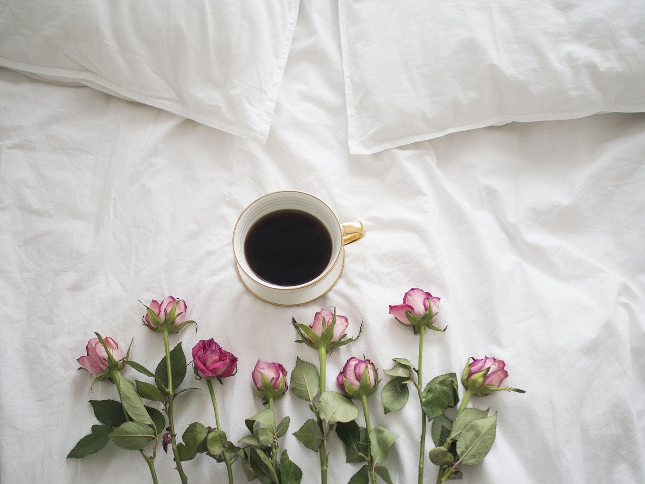 Immagine di un risveglio romantico con fiori e caffè, frasi dolci per un buongiorno speciale.